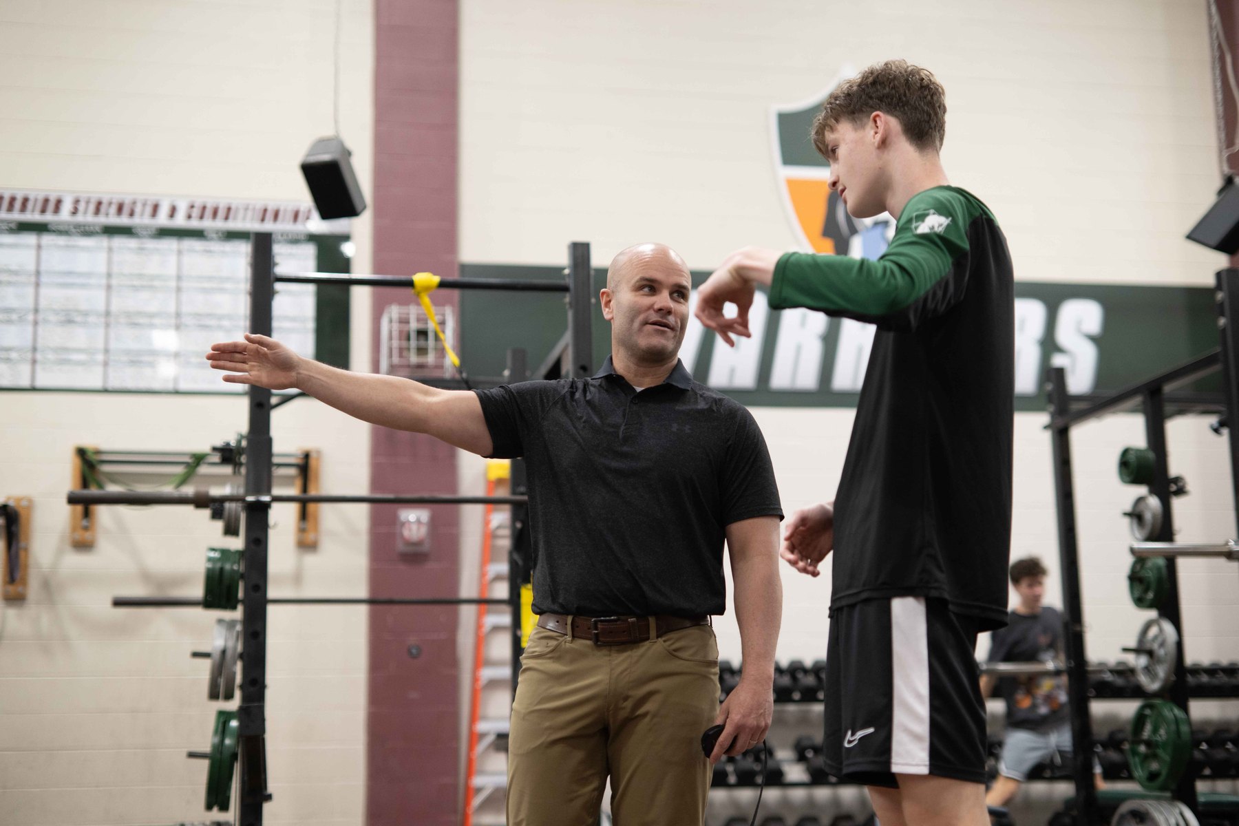 A Covenant coach working with an athlete in the strength and conditioning room